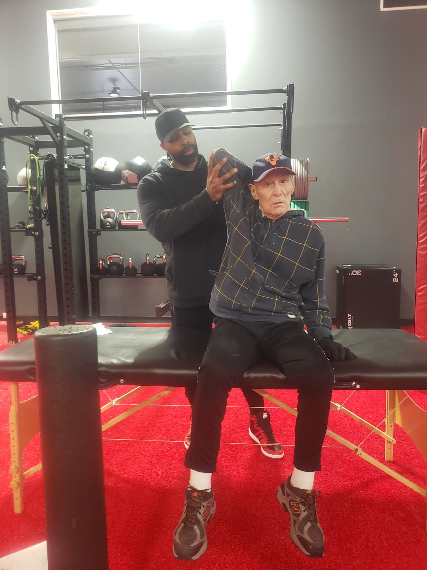 Daine Chang taking a client through an assisted shoulder stretch