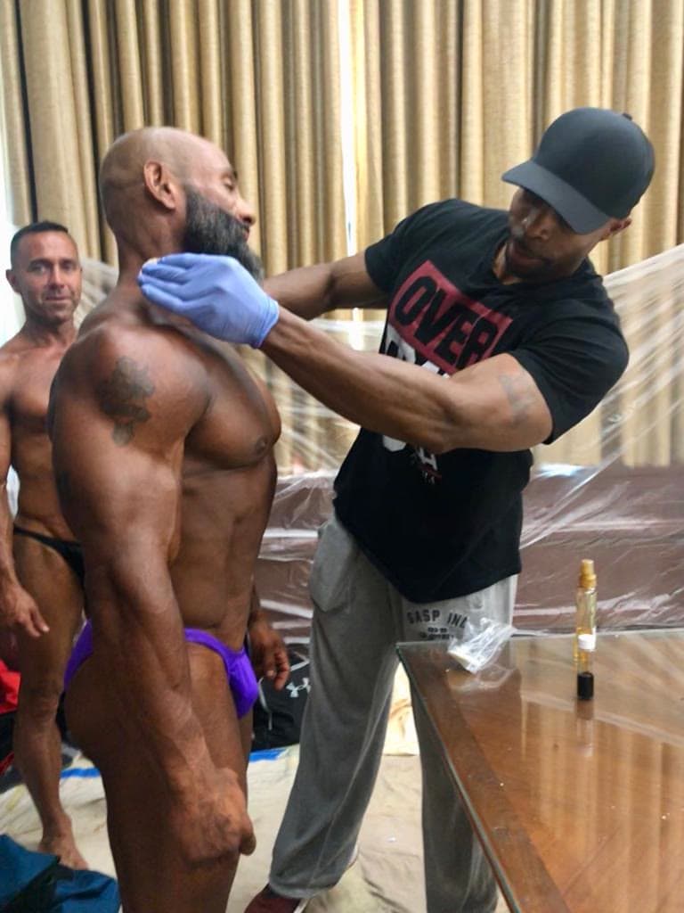 Daine Chang working on a bodybuilder backstage at a show