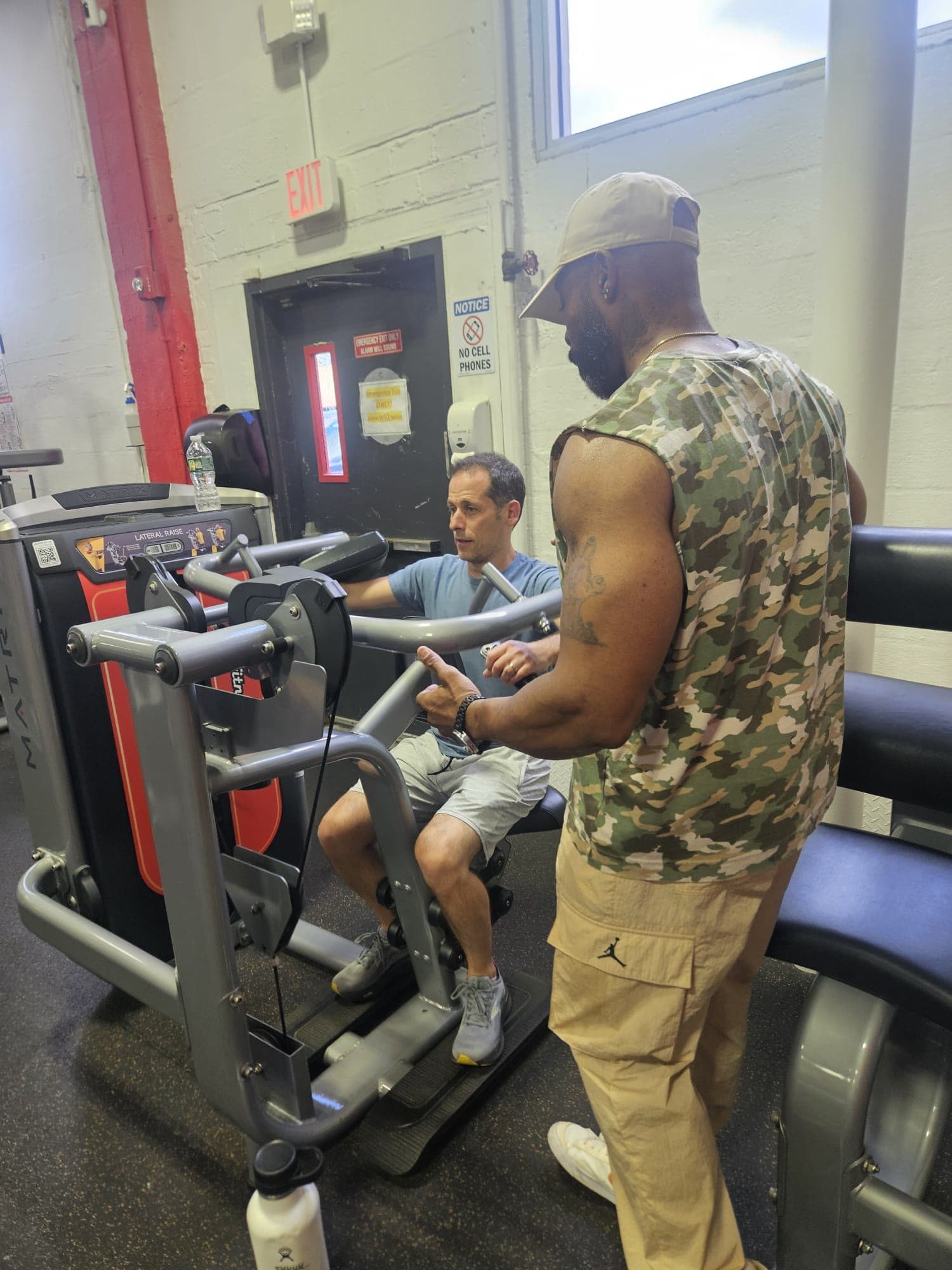 Daine Chang adjusting a client's position on a press machine